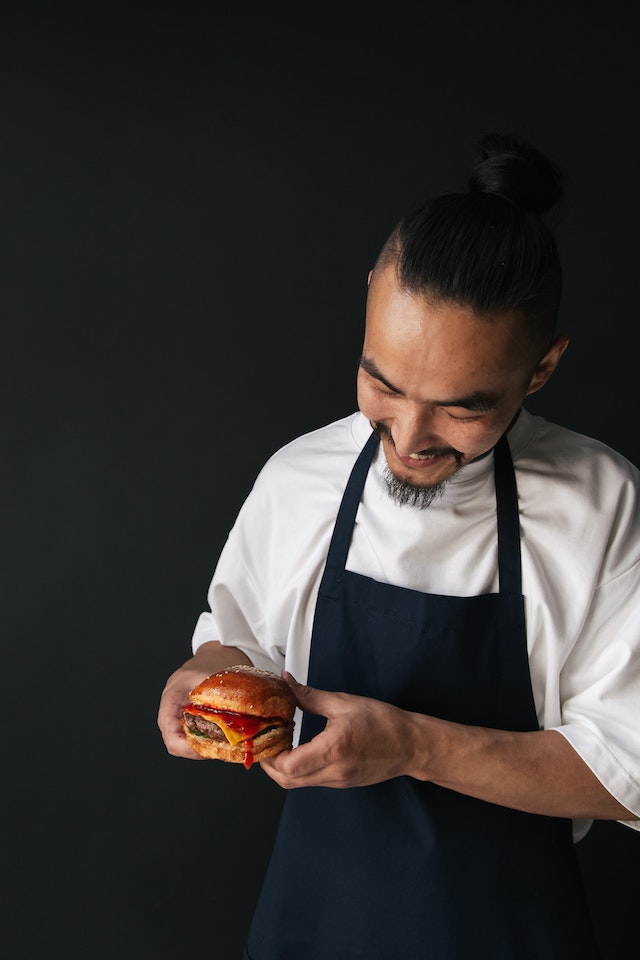 Guy smiles to his freshly made burger