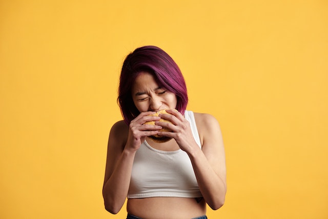 Girl takes bite on burger